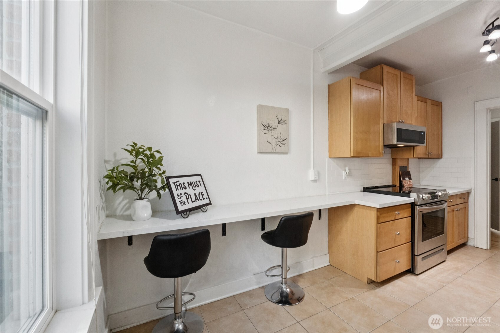 905 Northeast 43rd Street, Unit 108 Seattle, WA 98105 - Photo 10 of 28 a kitchen with stainless steel appliances granite countertop a stove a sink and a microwave