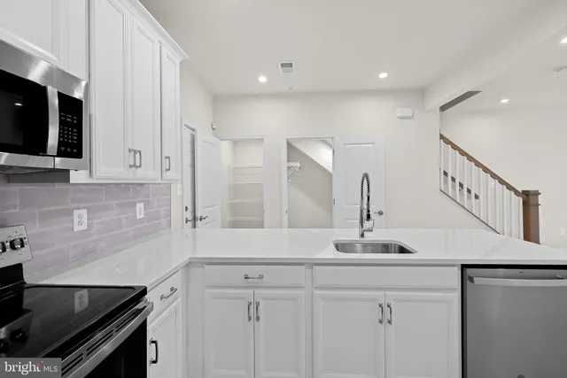 a kitchen with stainless steel appliances granite countertop a sink and a stove