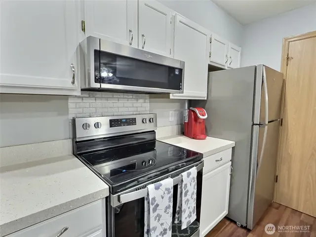a kitchen with stainless steel appliances a stove microwave and refrigerator