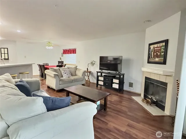 a living room with furniture a fireplace and a flat screen tv