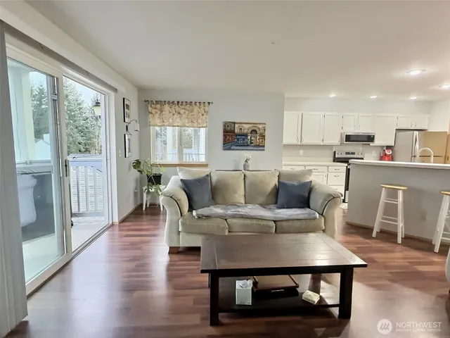 a living room with furniture a wooden floor and a large window