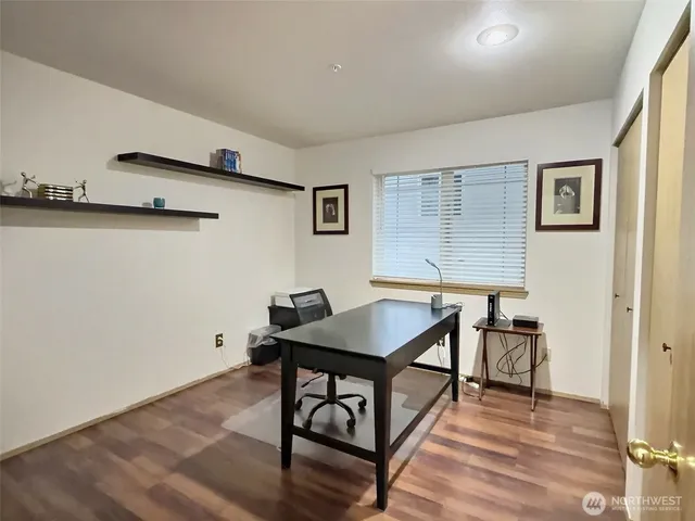 a view of a workspace with furniture and wooden floor