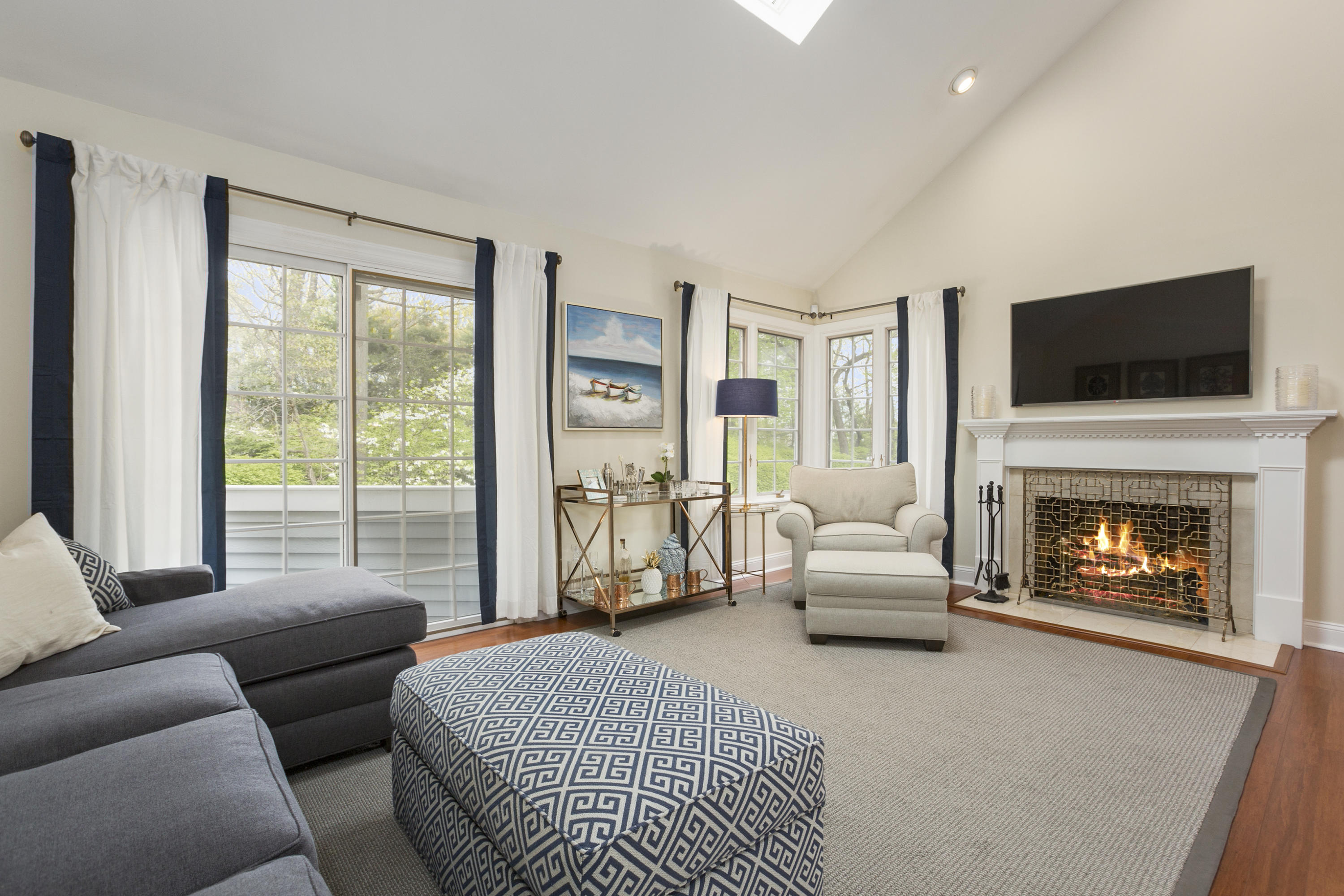 a living room with furniture a flat screen tv and a fireplace