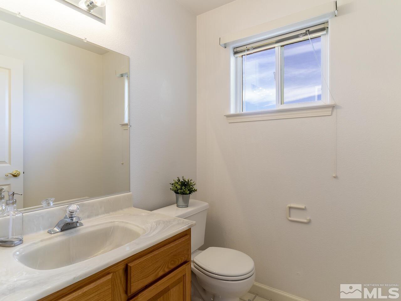 1090 Reese Way Reno, NV 89521 - Photo 25 of 33 a bathroom with a sink toilet and a mirror