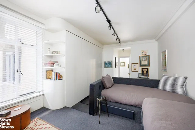 a bedroom with a bed couch and a window