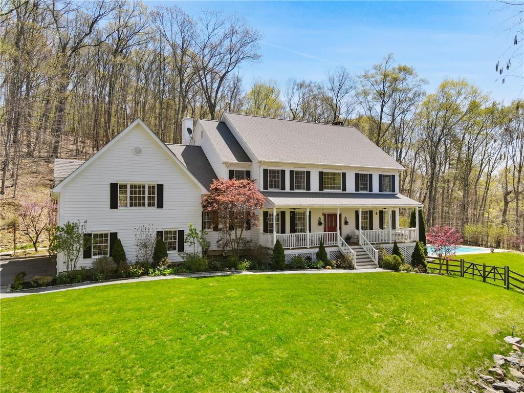 a front view of a house with a garden and trees