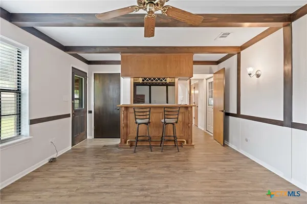 a view of a kitchen with furniture and wooden floor