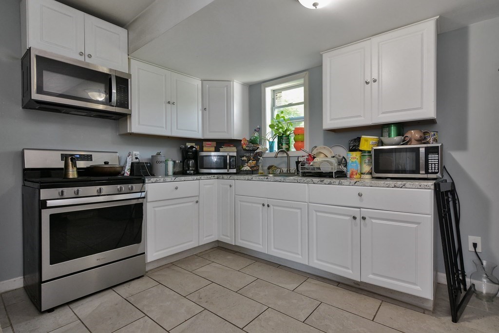10 Holly Street Lawrence, MA 01841 - Photo 20 of 32 a kitchen with cabinets stainless steel appliances and a sink