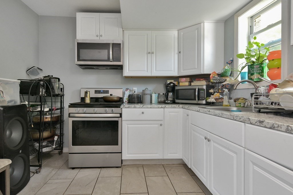10 Holly Street Lawrence, MA 01841 - Photo 21 of 32 a kitchen with cabinets stainless steel appliances and a sink