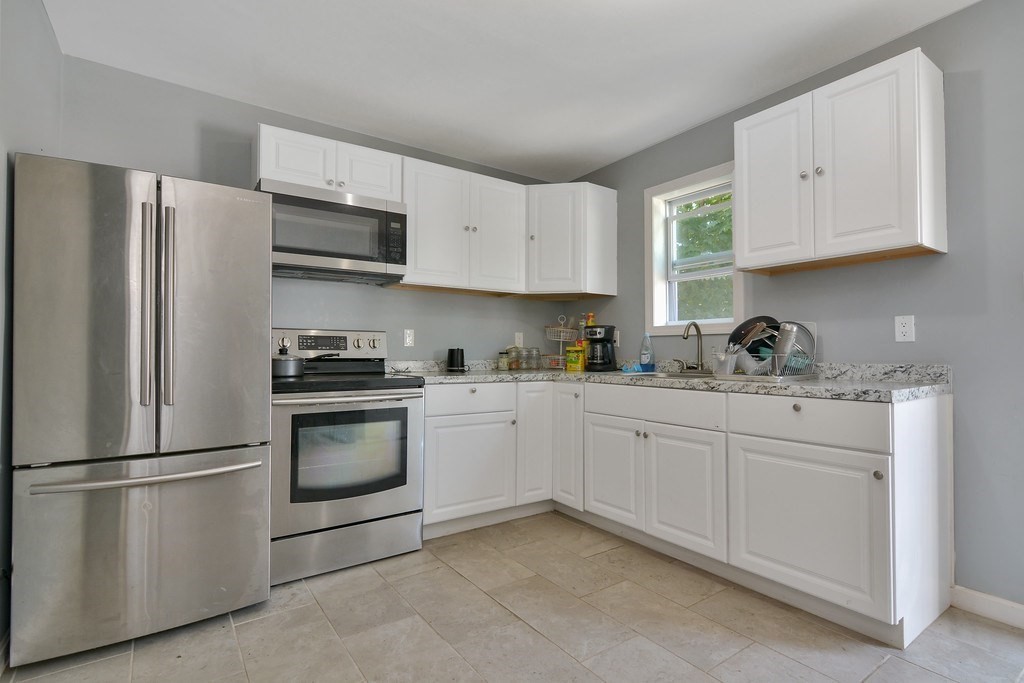 10 Holly Street Lawrence, MA 01841 - Photo 6 of 32 a kitchen with stainless steel appliances granite countertop a refrigerator sink and cabinets