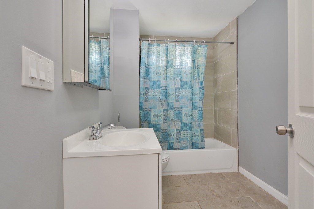 10 Holly Street Lawrence, MA 01841 - Photo 7 of 32 a bathroom with a sink a toilet and shower