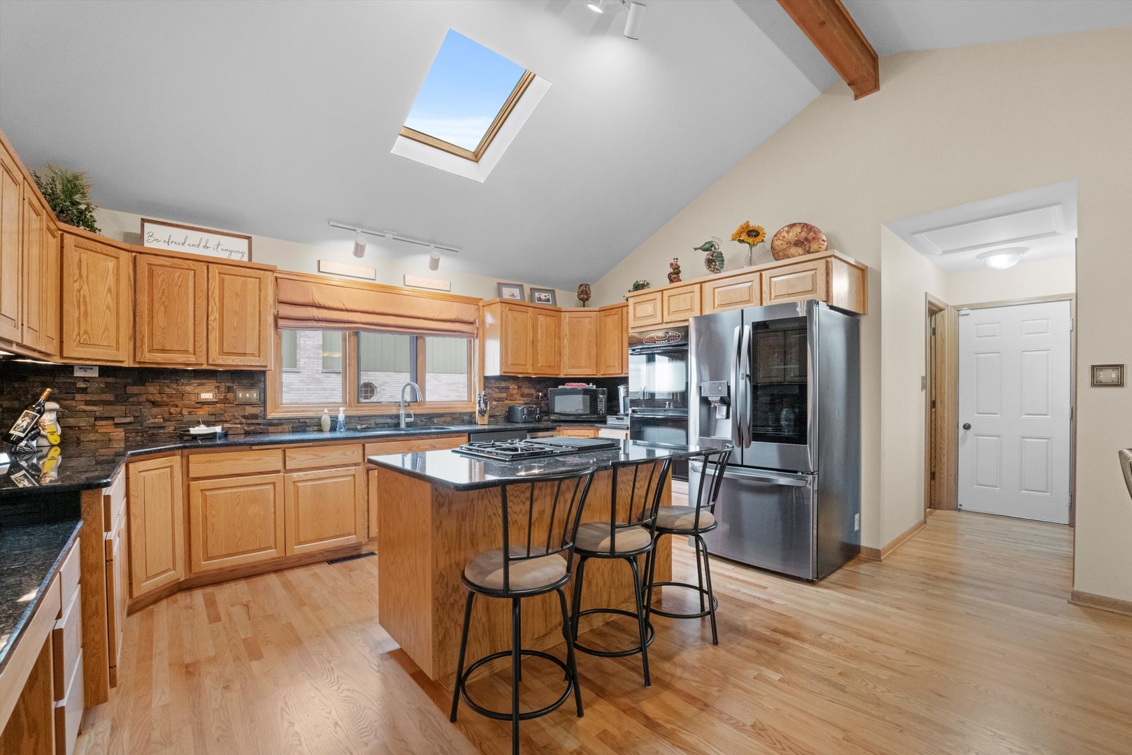 7428 Ridgefield Lane Tinley Park, IL 60487 - Photo 11 of 43 a kitchen with stainless steel appliances granite countertop a stove top oven a sink dishwasher and a refrigerator with wooden floor