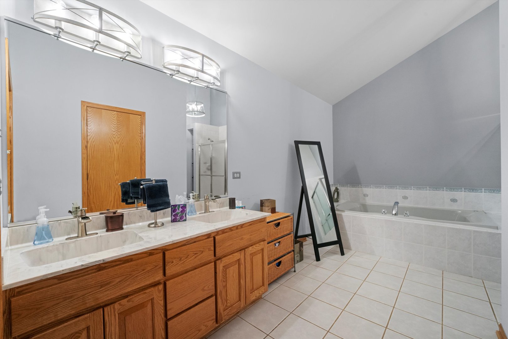 7428 Ridgefield Lane Tinley Park, IL 60487 - Photo 22 of 43 a bathroom with a double vanity sink a mirror and a bathtub