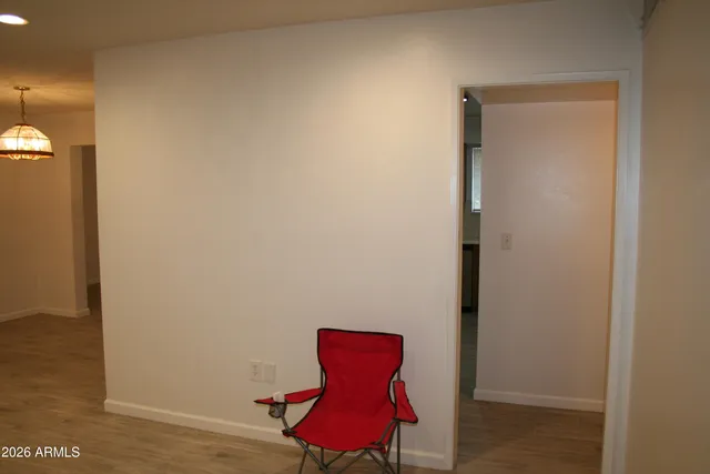 an empty room that has a window and wooden floor