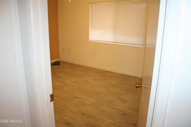 a view of a small space with wooden floor and a fan