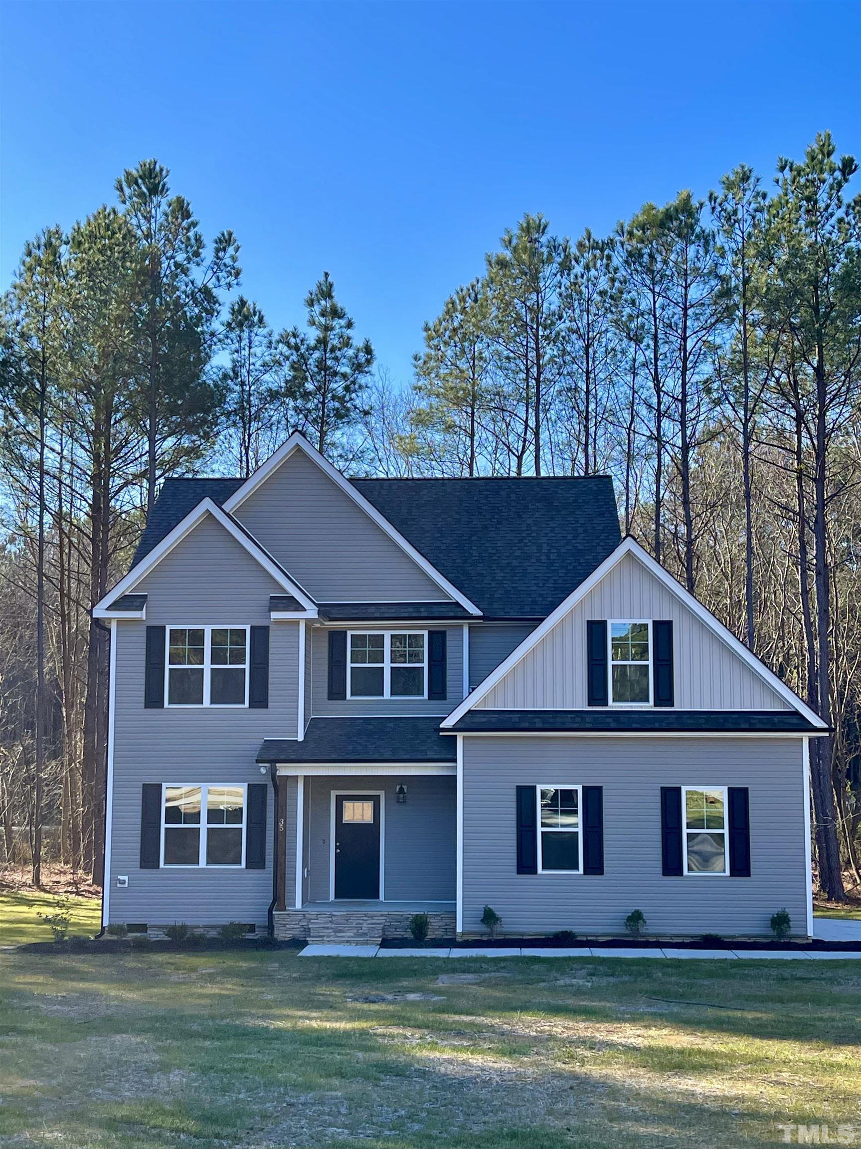 a view of a big house with a big yard and large trees