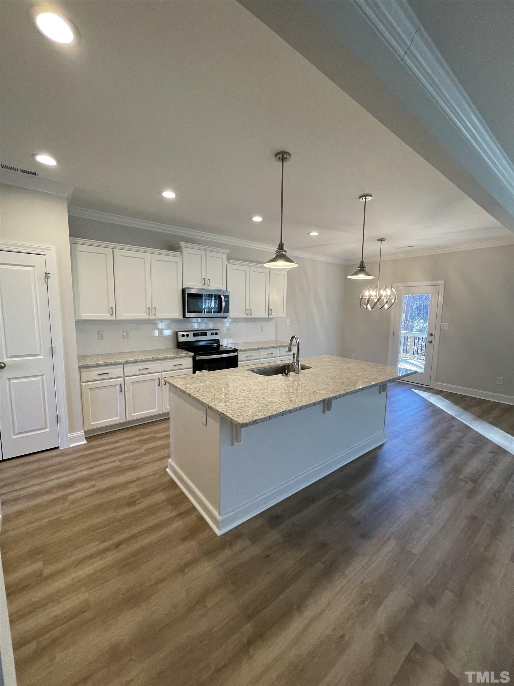 35 Mulberry Road Spring Hope, NC 27882 - Photo 4 of 32 a large white kitchen with wooden floors stainless steel appliances and a fireplace