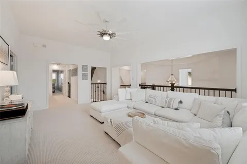 a living room with furniture white walls and chandelier