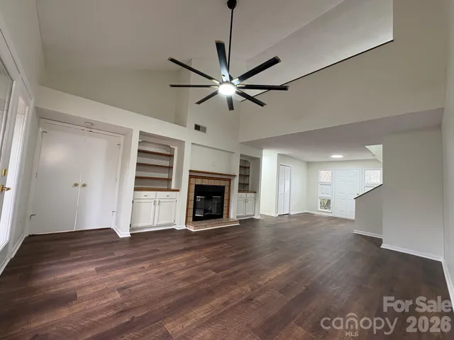 a hallway with wooden floor fireplace and windows