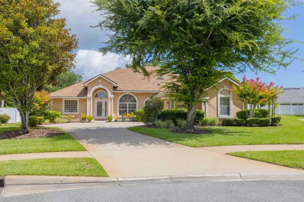 a view of house with outdoor space and trees in the background