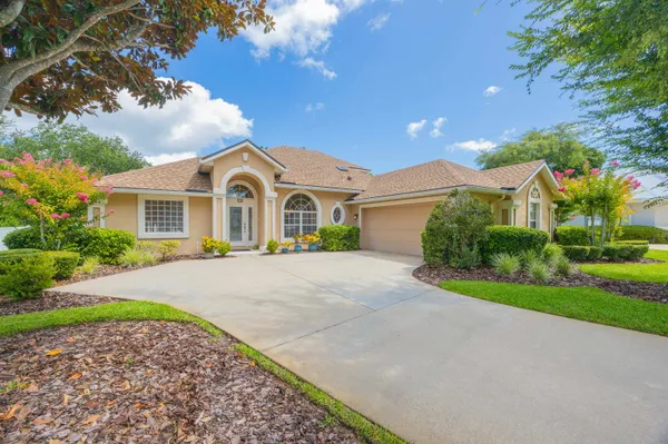 a dining room with wooden floor a chandelier a wooden table and chairs