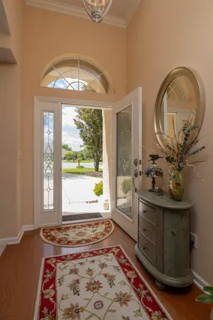 a kitchen with stainless steel appliances granite countertop a refrigerator a sink a stove top oven and a dining table with wooden floor