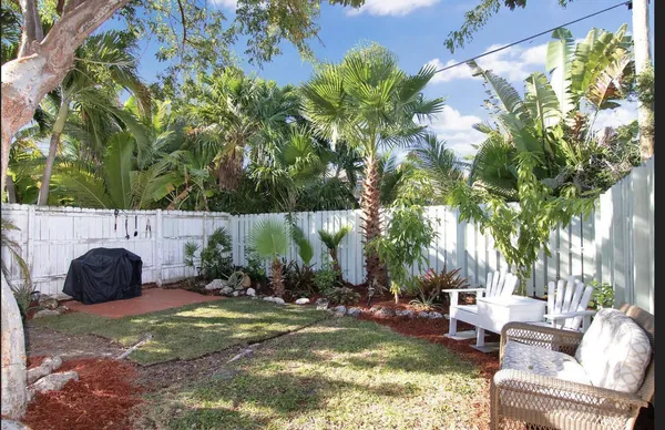 a backyard of a house with table and chairs