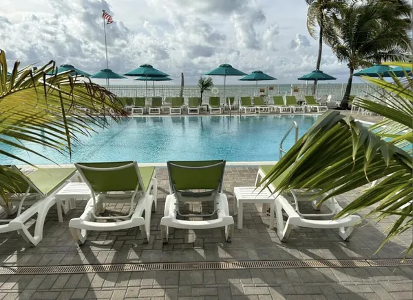 a view of a lake with couches and table under an umbrella