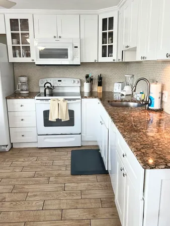 a kitchen with stainless steel appliances granite countertop a sink stove and cabinets