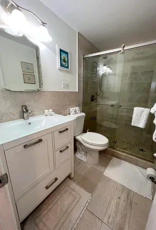 a bathroom with a double vanity sink toilet and shower