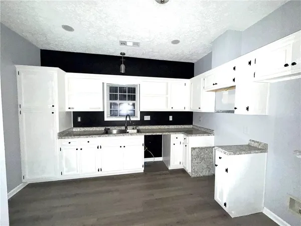 a kitchen with cabinets a sink and white appliances