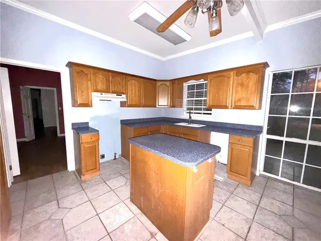 a kitchen with granite countertop a sink a counter top space and cabinets