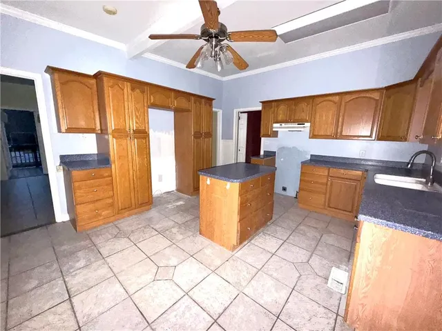 a kitchen with a sink a stove cabinets and counter space
