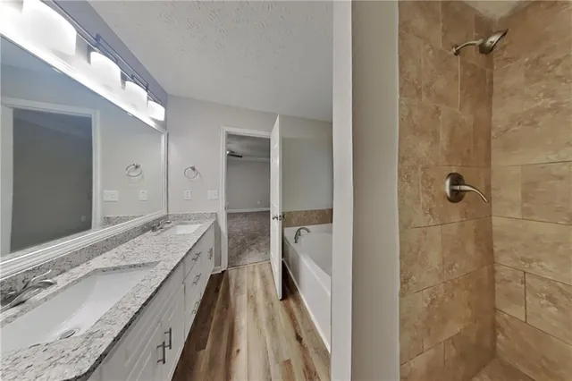 a en suite bathroom with a granite countertop sink and shower