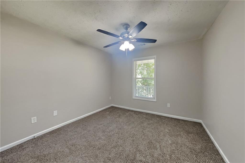3013 Rockview Drive Loganville, GA 30052 - Photo 16 of 19 an empty room with a window and a fan