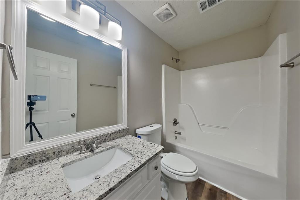 3013 Rockview Drive Loganville, GA 30052 - Photo 17 of 19 a bathroom with a granite countertop sink toilet and shower