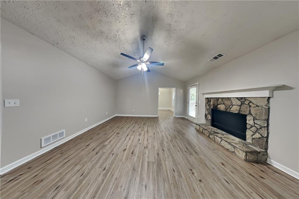 3013 Rockview Drive Loganville, GA 30052 - Photo 2 of 19 wooden floor in an empty room with a fireplace