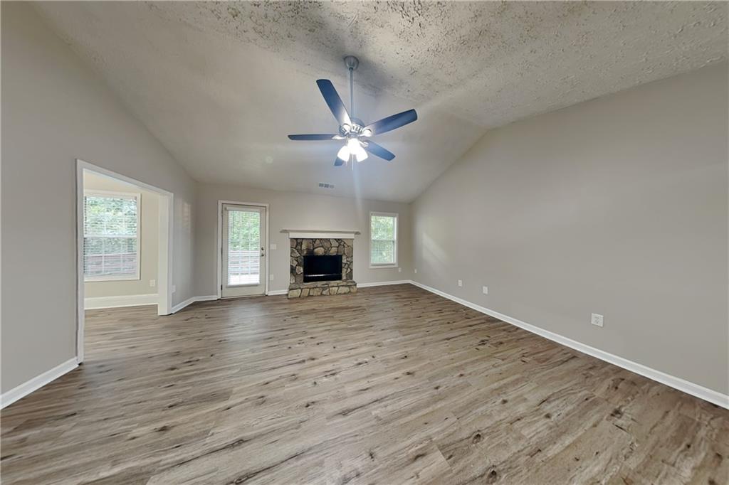 3013 Rockview Drive Loganville, GA 30052 - Photo 3 of 19 an empty room with wooden floor ceiling fan and windows