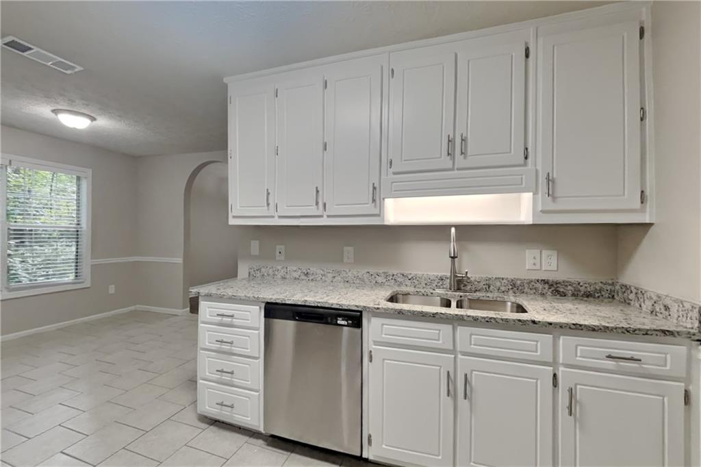 3013 Rockview Drive Loganville, GA 30052 - Photo 5 of 19 a kitchen with granite countertop white cabinets and a sink
