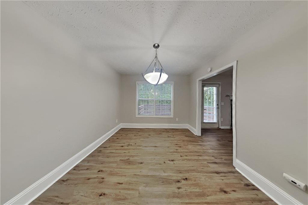 3013 Rockview Drive Loganville, GA 30052 - Photo 7 of 19 a view of an empty room with wooden floor and a window