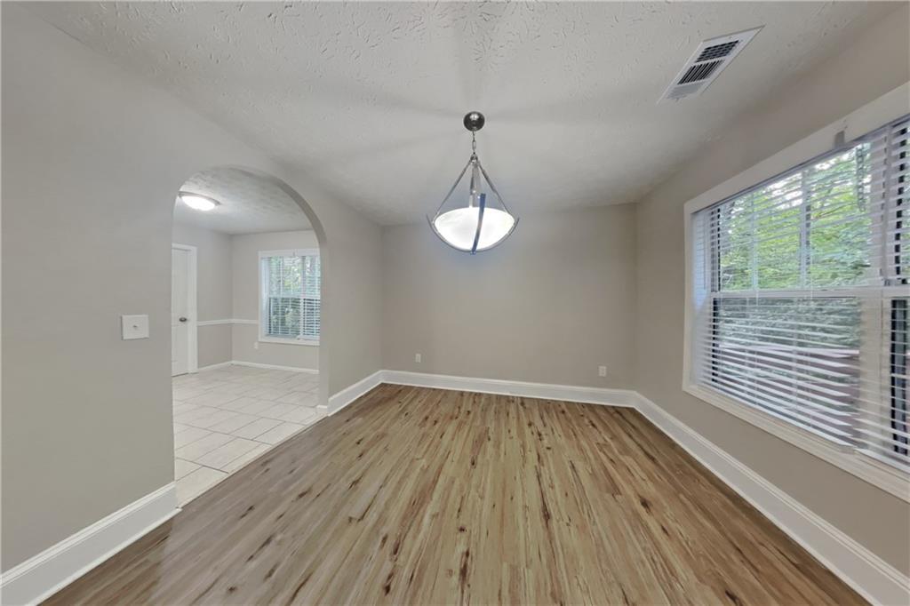 3013 Rockview Drive Loganville, GA 30052 - Photo 8 of 19 wooden floor in an empty room with a window