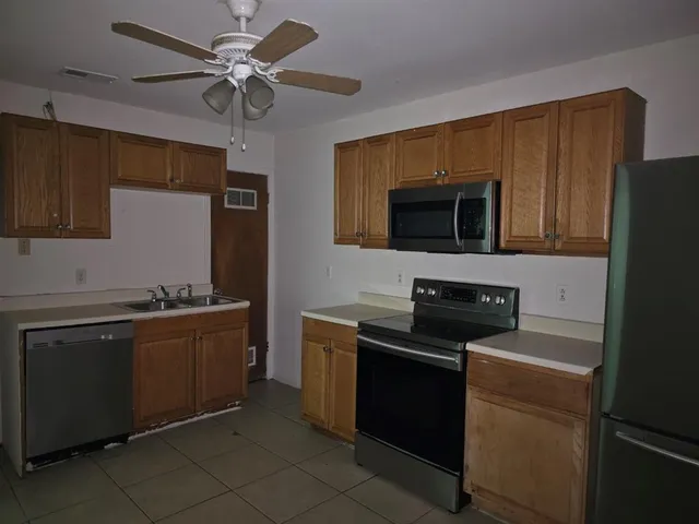 a kitchen with stainless steel appliances a stove microwave and refrigerator