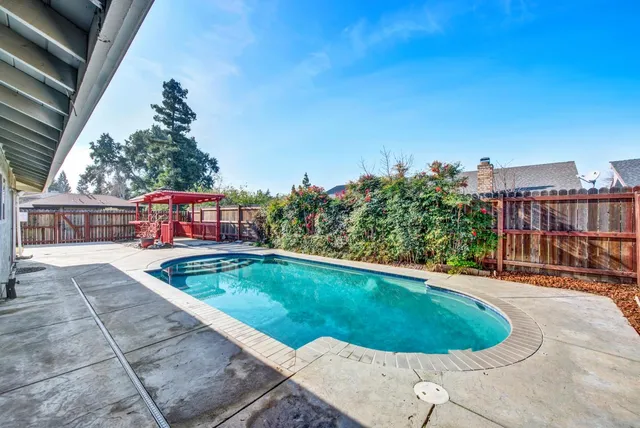 a view of backyard with swimming pool and outdoor seating