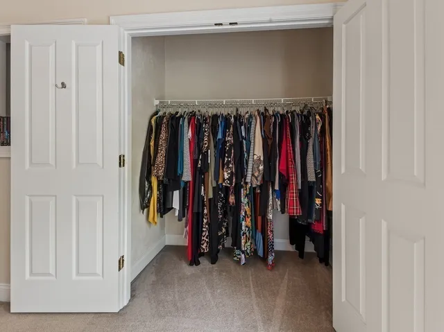 a view of walk in closet with clothes