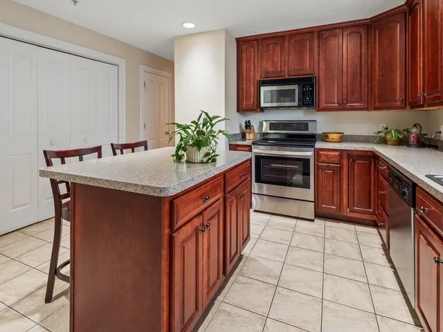 a kitchen with stainless steel appliances granite countertop a stove a sink and a microwave