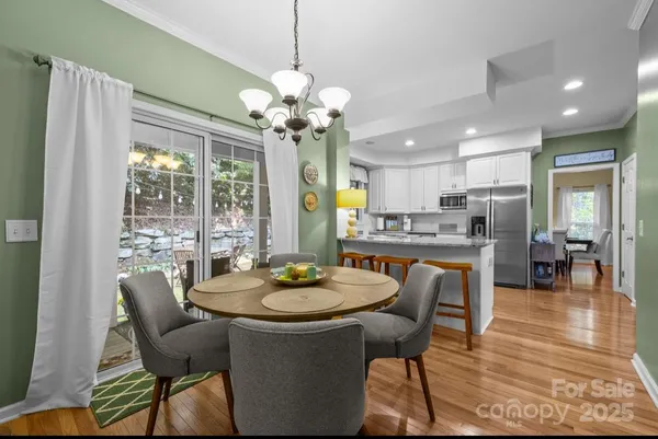 a dining room filled chandelier and wooden floor