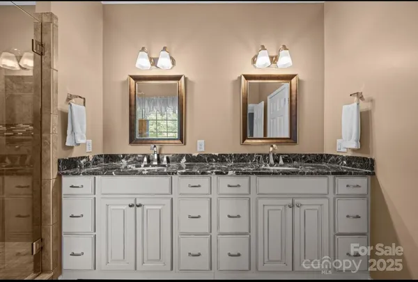 a bathroom with double sink and a mirror