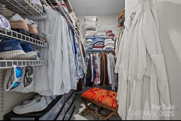 a view of walk in closet with clothes and shoes