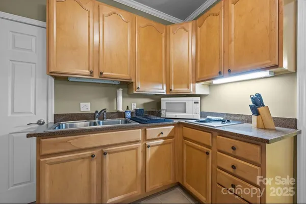 a kitchen with stainless steel appliances granite countertop a sink and dishwasher with wooden cabinets