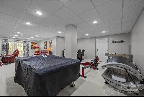 a room with furniture a air conditioner vent and a window